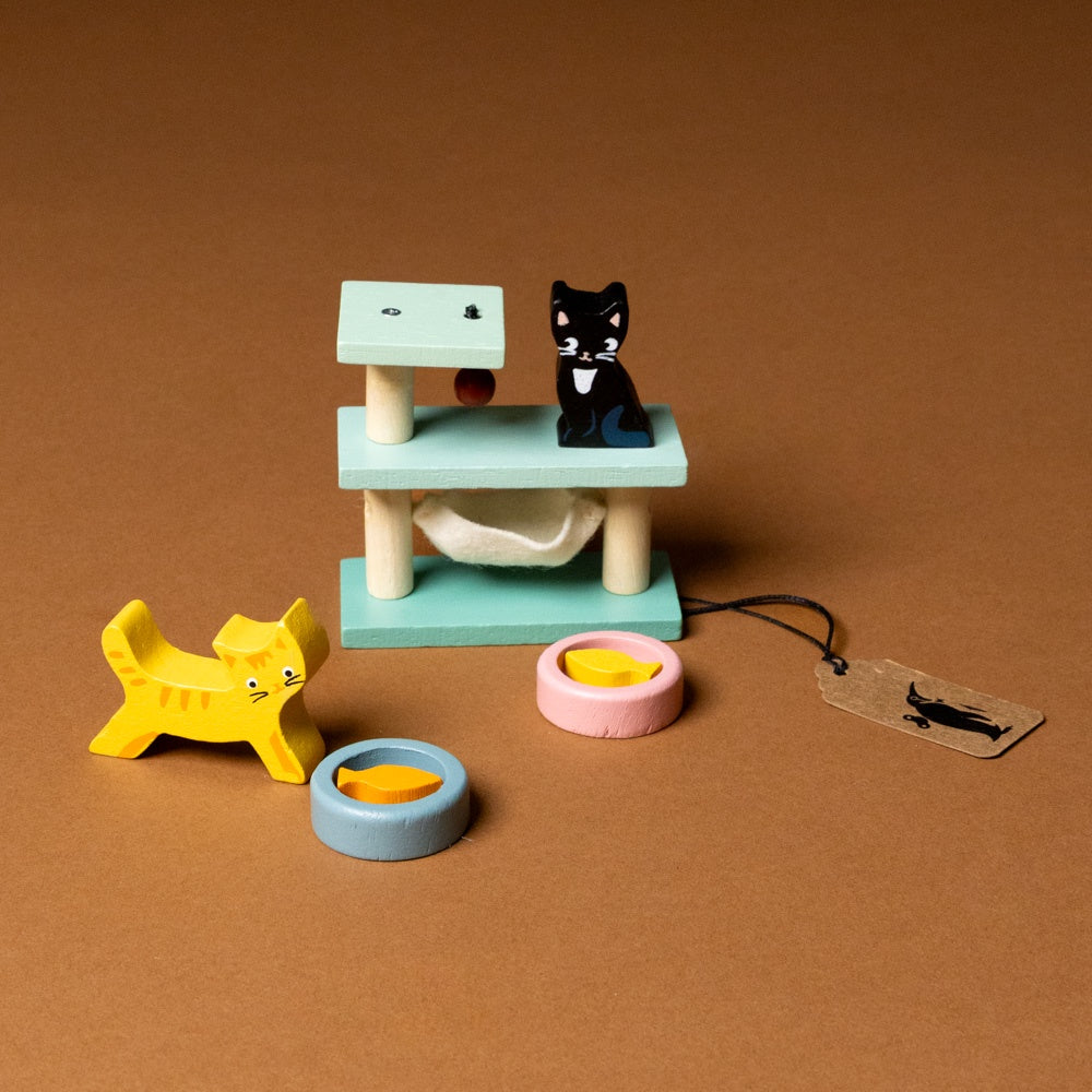 wooden-pet-play-set-cat of colorful cat toys including a tree, hammock, and bowls on a brown background