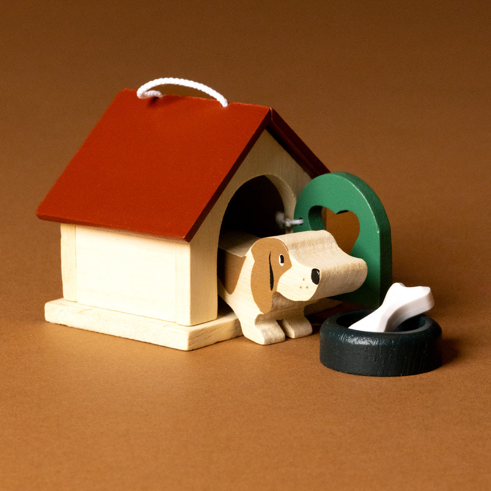 wooden-pet-play-set-dog Wooden doghouse with a toy dog, bone, and wheel on a brown background