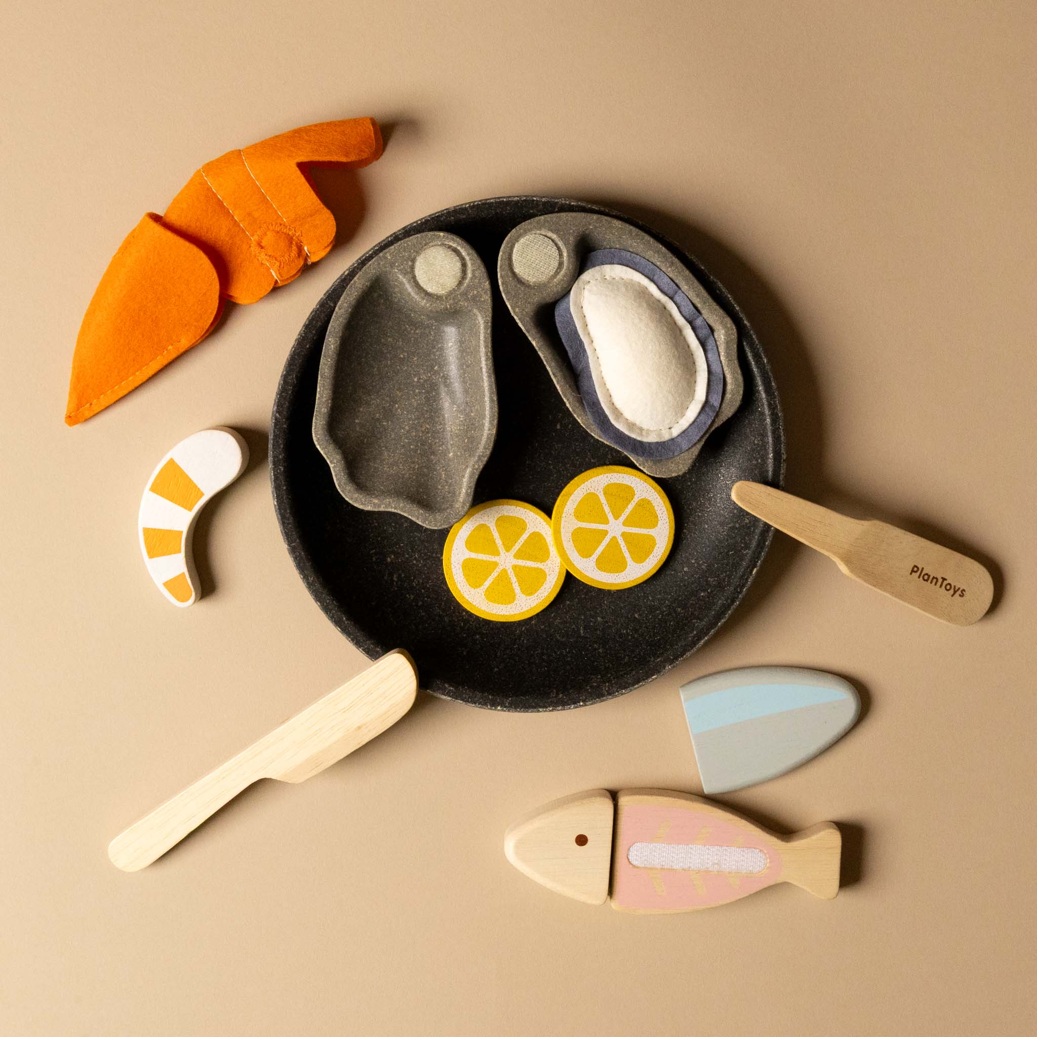 Set of wooden toy food items including a plate with fish, lemon slices, and carrots