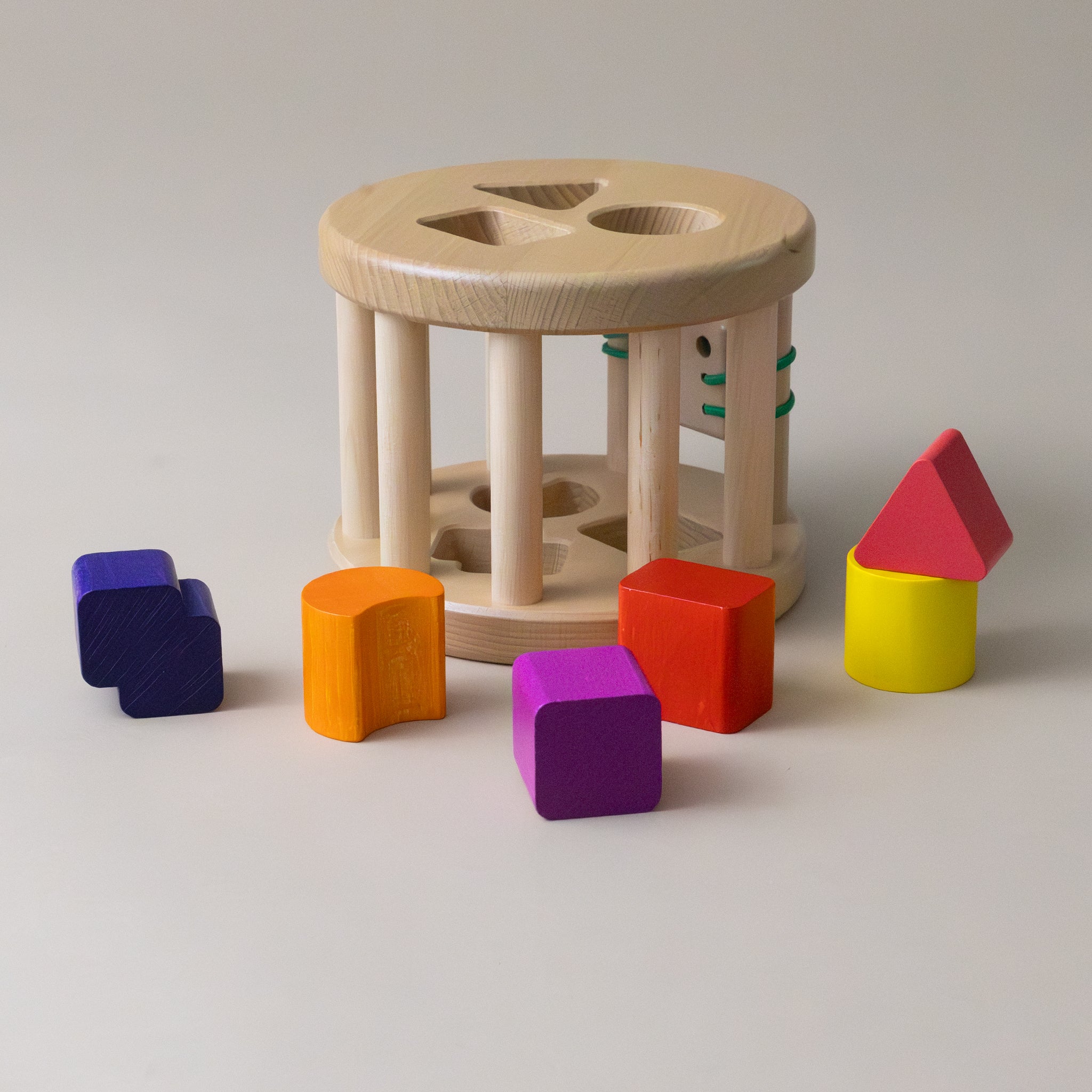 colorful-triangle-cylinder-and-cube-shapes-next-to-shape-sorter