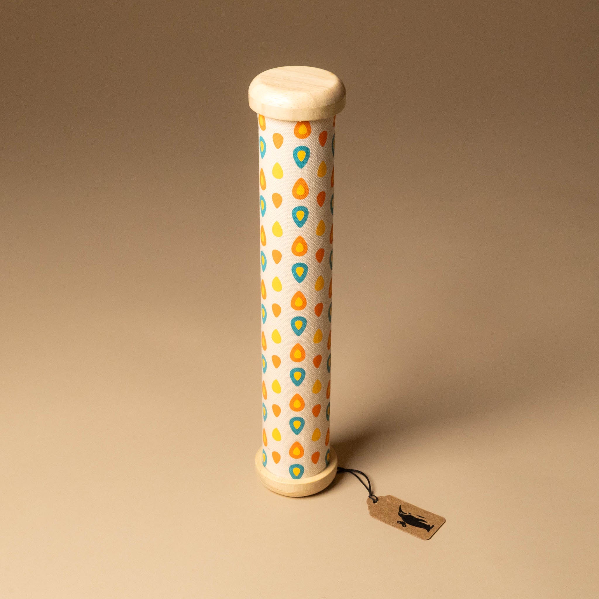 Cylindrical wooden-rainmaker-stick with a patterned design on a beige background