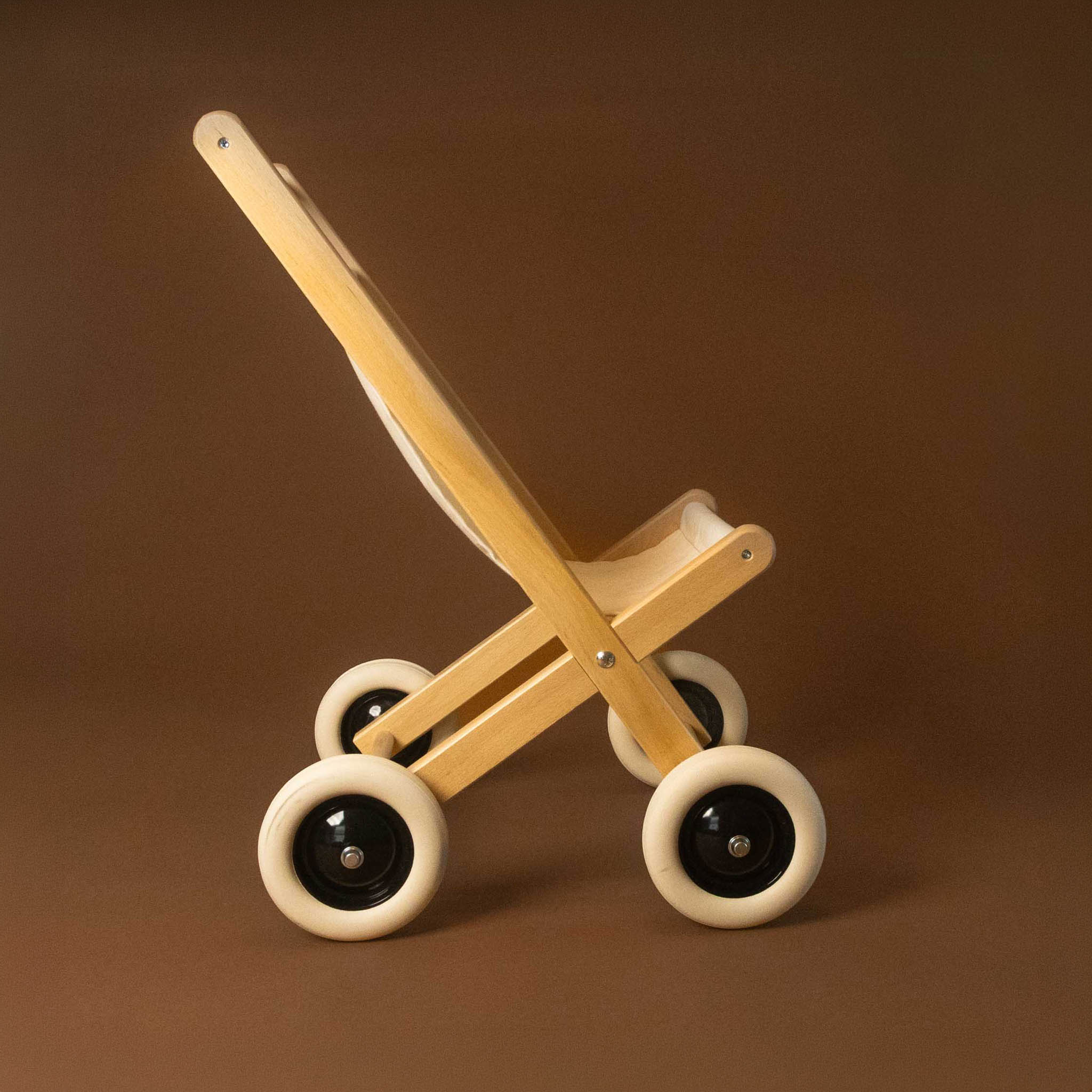 Wooden toy stroller with wheels on a brown background