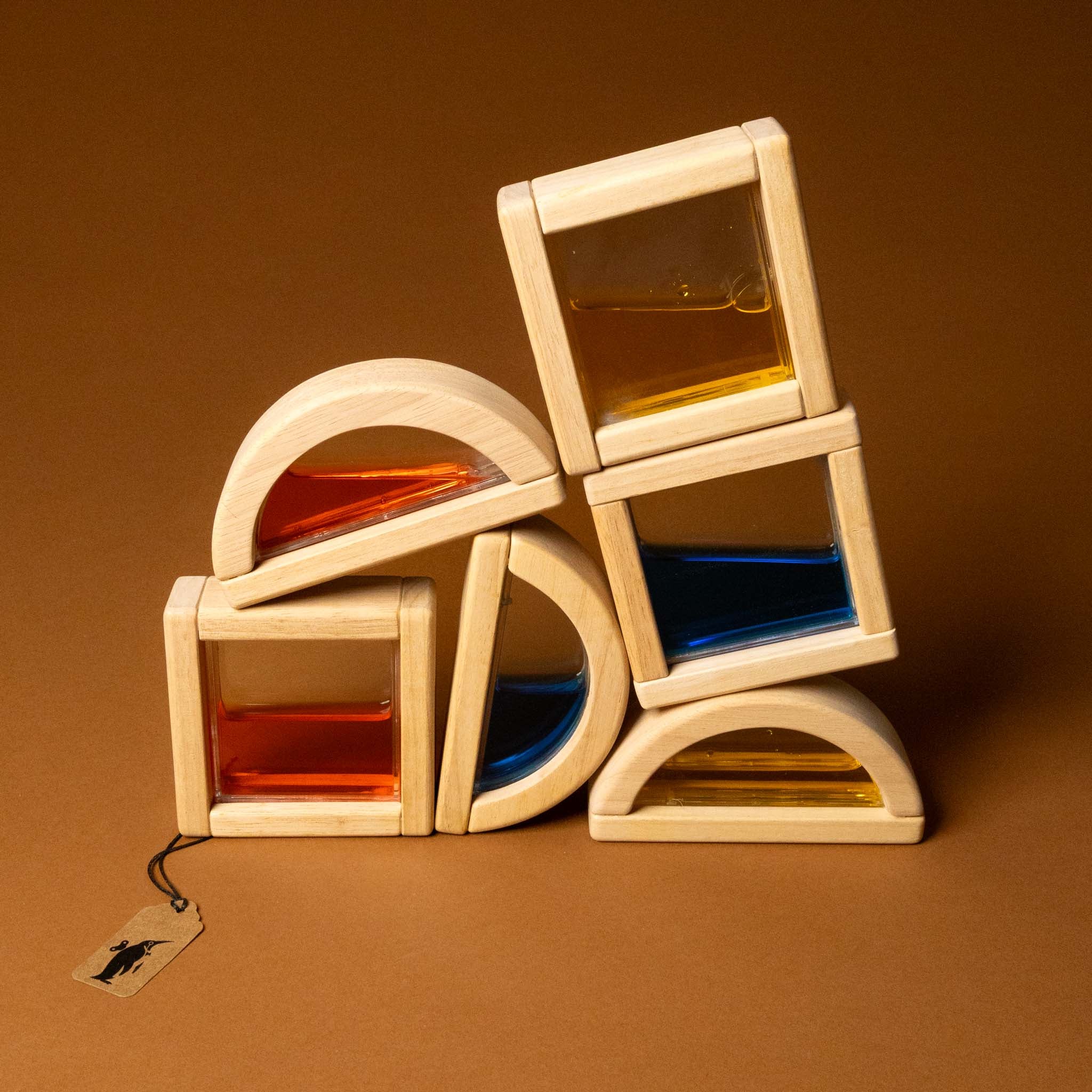 Stack of wooden geometric shapes with colored liquids on a brown background
