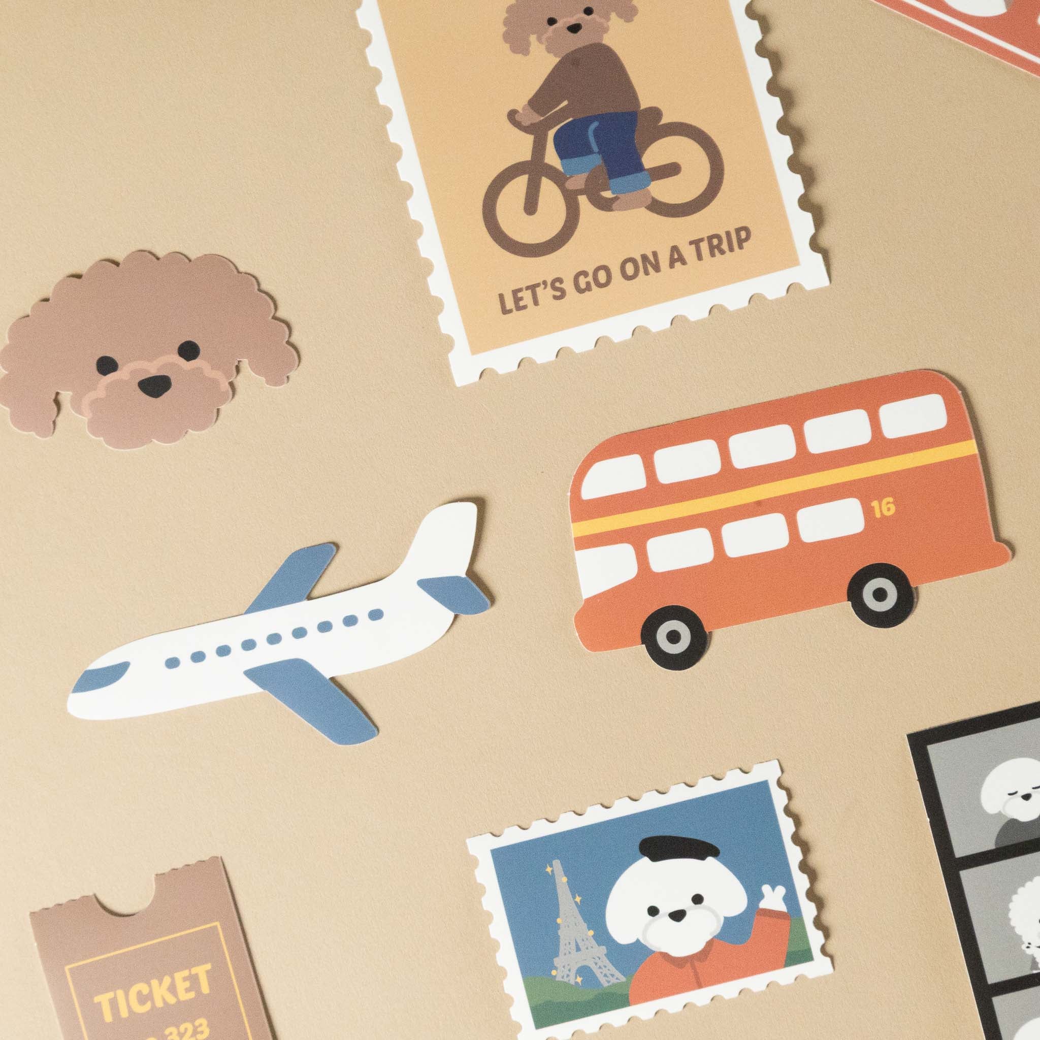 Collection of travel-themed stickers including a dog on a bike, airplane, red bus, and scenic stamps on a beige background.