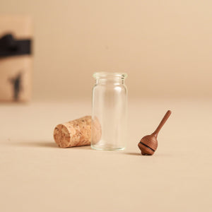 bell-shaped-wooden-top-next-to-glass-jar