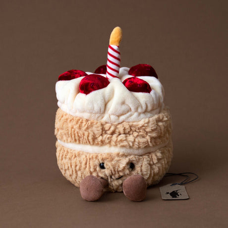 birthday-cake-stuffed-animal-with-smiling-face-red-striped-candle-and-strawberry-topping