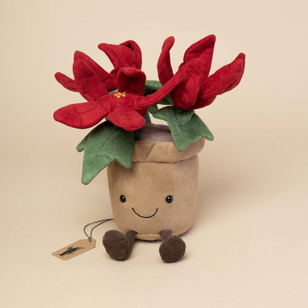 red-poinsettia-in-brown-pot-stuffed-animal-with-smiling-face-and-corduroy-feet