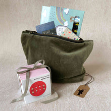 Load image into Gallery viewer, budding-artist-gift-set-showing-a-moss-green-velvet-pouch-holding-thoughtfulls-cards-magic-markers-block-crayons-and-sitting-next-to-a-red-button-pom-maker