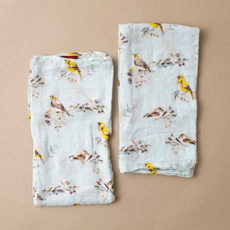 two-folded-light-blue-cloths-with-grey-and-yellow-perched-birds