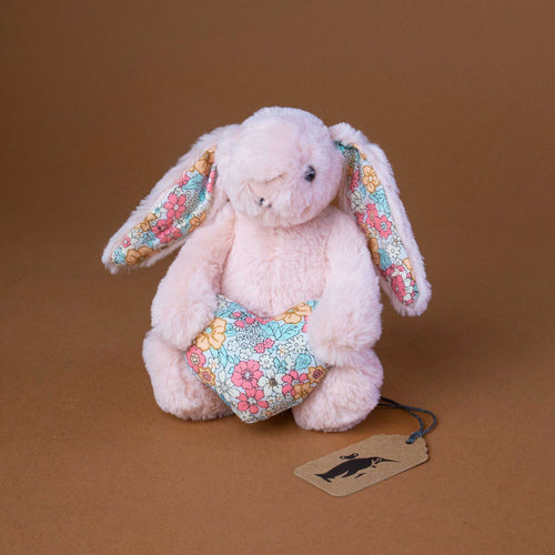 small-blush-colored-bunny-holding-a-small-blossom-patterned-heart-in-front