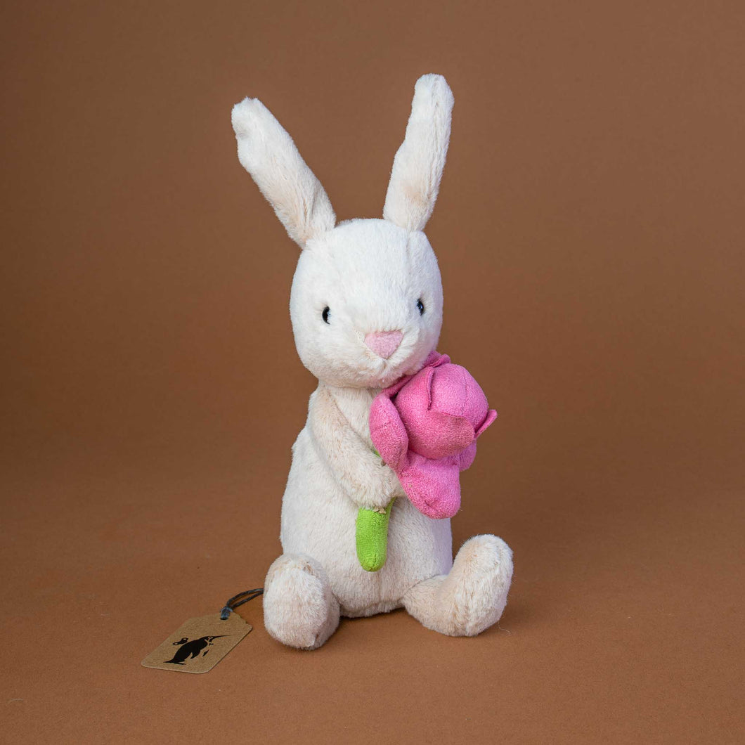 oatmeal-colored-bunny-with-long-ears-holding-a-pink-peony-in-hands