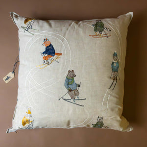 downhill-woodland-animial-skiers-pillow-on-oatmeal-linen-fabric-with-white-snowtrack