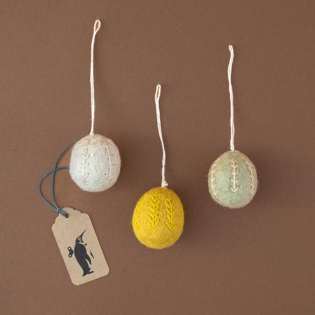 three-felted-and-embroidered-eggs-in-white-yellow-and-sage-green