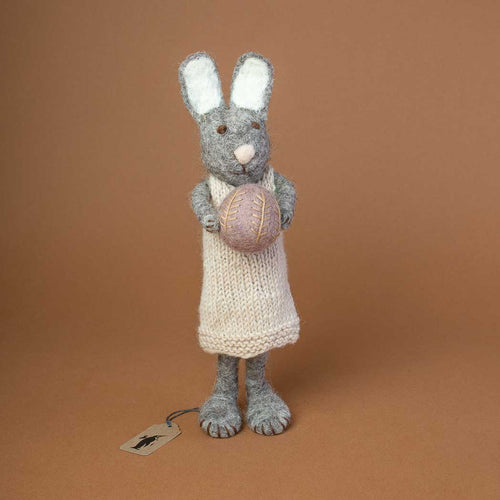 big-grey-rabbit-with-knitted-beige-dress-holding-a-lavender-colored-easter=egg