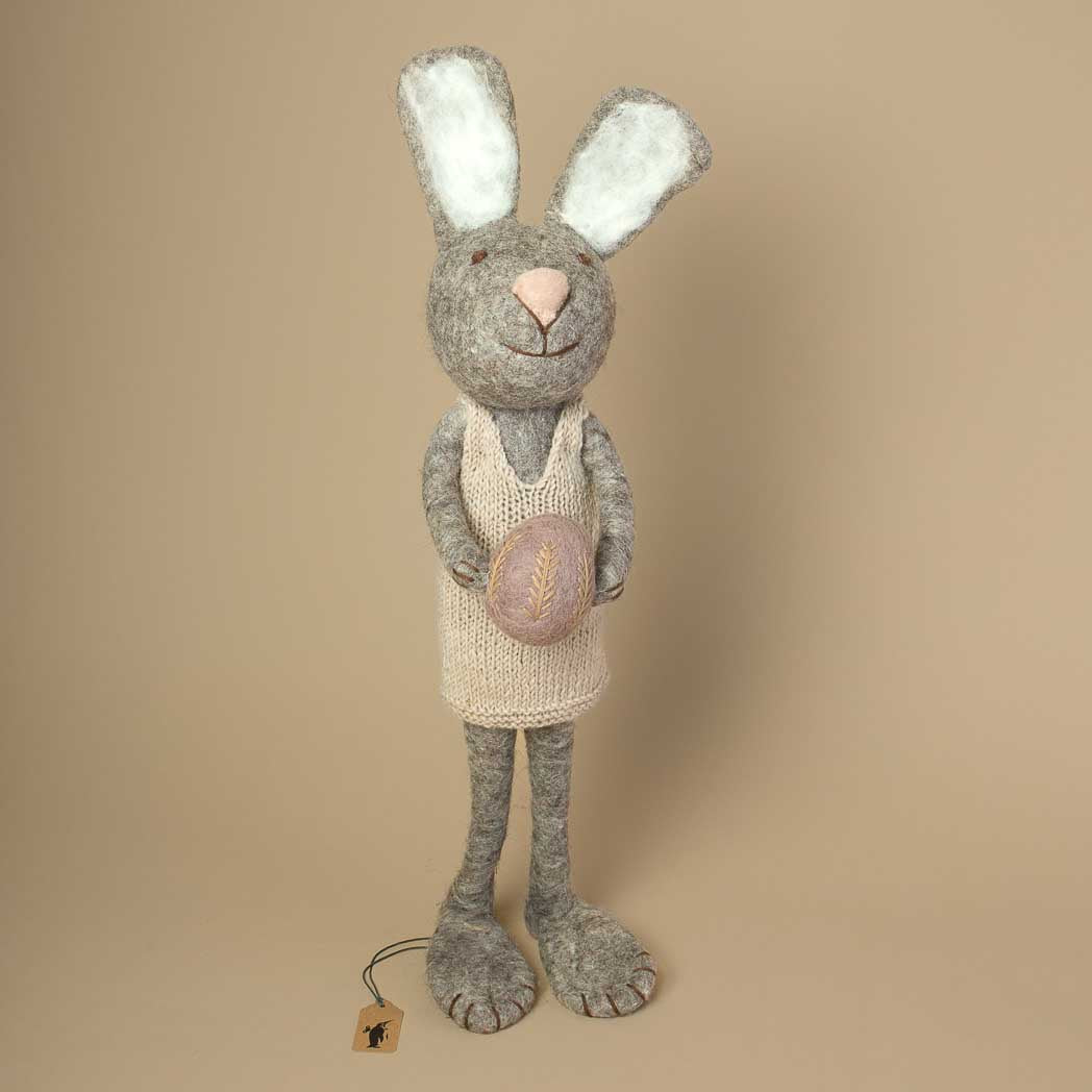 grey-felted-jumbo-sized-rabbit-with-knitted-beige-dress-holding-a-lavender-colored-and-embroidered-egg-in-her-hands