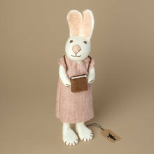 Load image into Gallery viewer, white-felted-bunny-wearing-a-lavender-colored-dress-and-backpack-holding-a-brown-book-in-her-hands