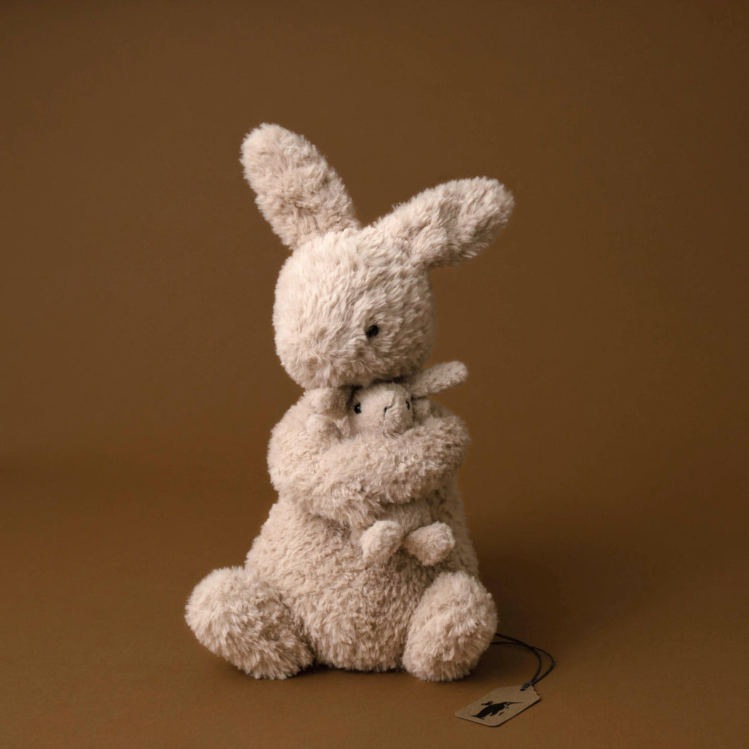 beige-bunny-sitting-holding-smaller-beige-bunny-baby