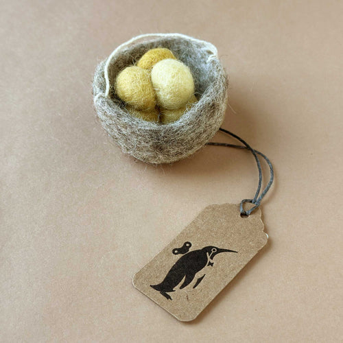 grey felted nest ornament with three little yellow eggs