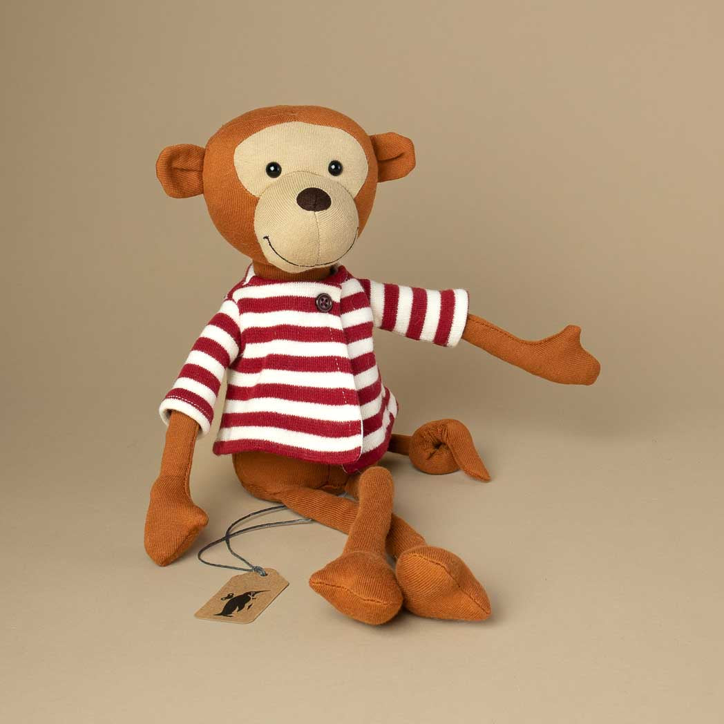 brown-monkey-with-long-arms-and-legs-sitting-and-wearing-a-red-white-striped-jacket-with-button