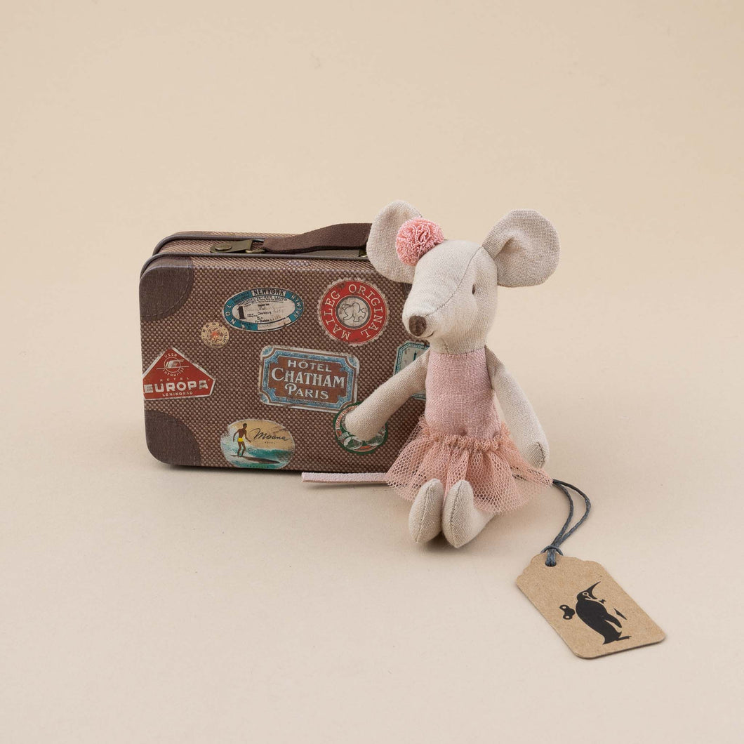 mouse-in-pink-outfit-next-to-brown-suitcse-with-travel-stickers