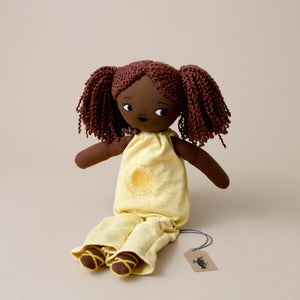 organic-cotton-friend-sol-with-dark-skin-natural-hair-in-two-pony-tails-wearing-yellow-jumpsuit-with-embroidered-sun