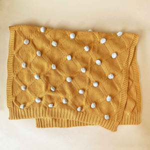 butterscoth-organic-knit-blanket-with-grey-pom-poms-unfolded