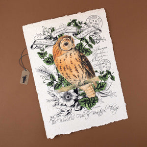 handmade-paper-with-illustration-of-an-owl-sitting-on a-branch-surrounded-by-leaves-and-flowers