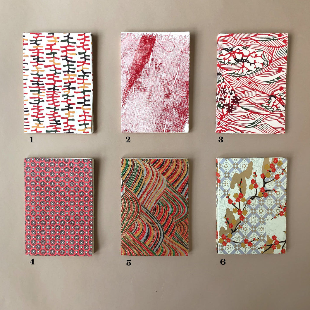 six-petite-hand-bound-notebooks-in-red-tones-ladders-tarlatan-rolling-hills-flower-dot-waves-and-golden-blossoms