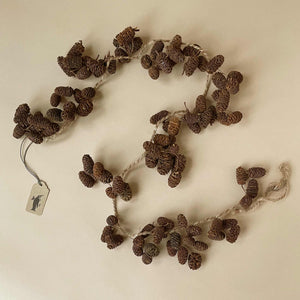 pinecone-garland-curved-into-an-s-shape-with-brown-twine-threaded-through-and-hooked-into-loops-on-either-end