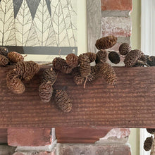 Load image into Gallery viewer, pinecone-garland-draped-over-a-fireplace