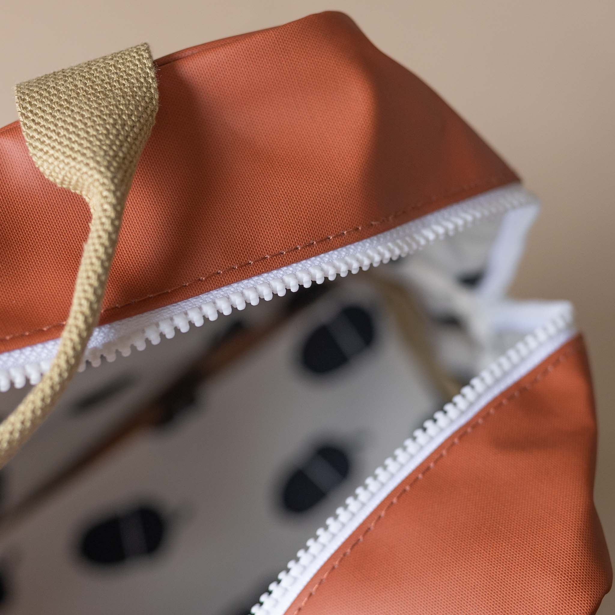 close-up-white-zip-khaki-handle-on-red-backpack