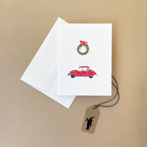 red-citroen-on-white-background-with-christmas-wreath-above-it-with-white-envelope