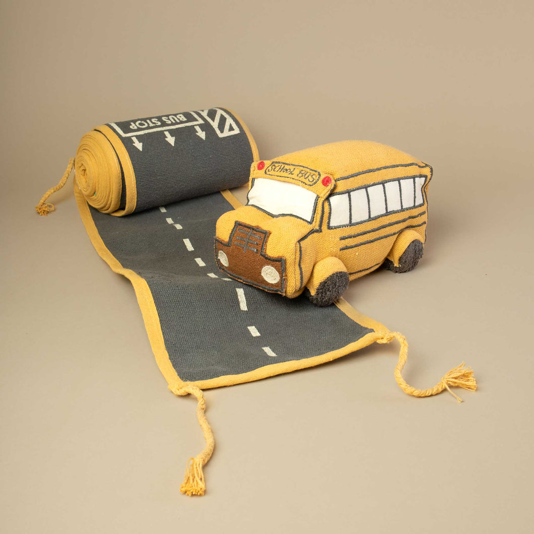 yellow-school-bus-on-a-roll-of-fabric-that-looks-like-a-road
