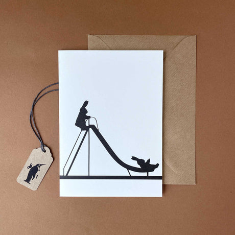 white-card-black-image-of-bunny-climbing-a-slide-and-sliding-down