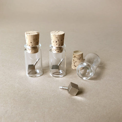metal-cube-tops-in-glass-jar-with-cork-stopper