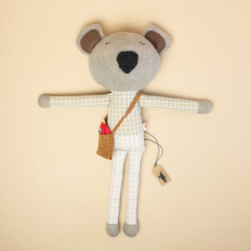 stuffed-bear-with-plaid-shirt-and-pants-brown-bag-holding-red-birdie