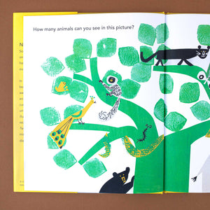 open-book-showing-illustration-of-a-green-tree-with-many-animals-in-it