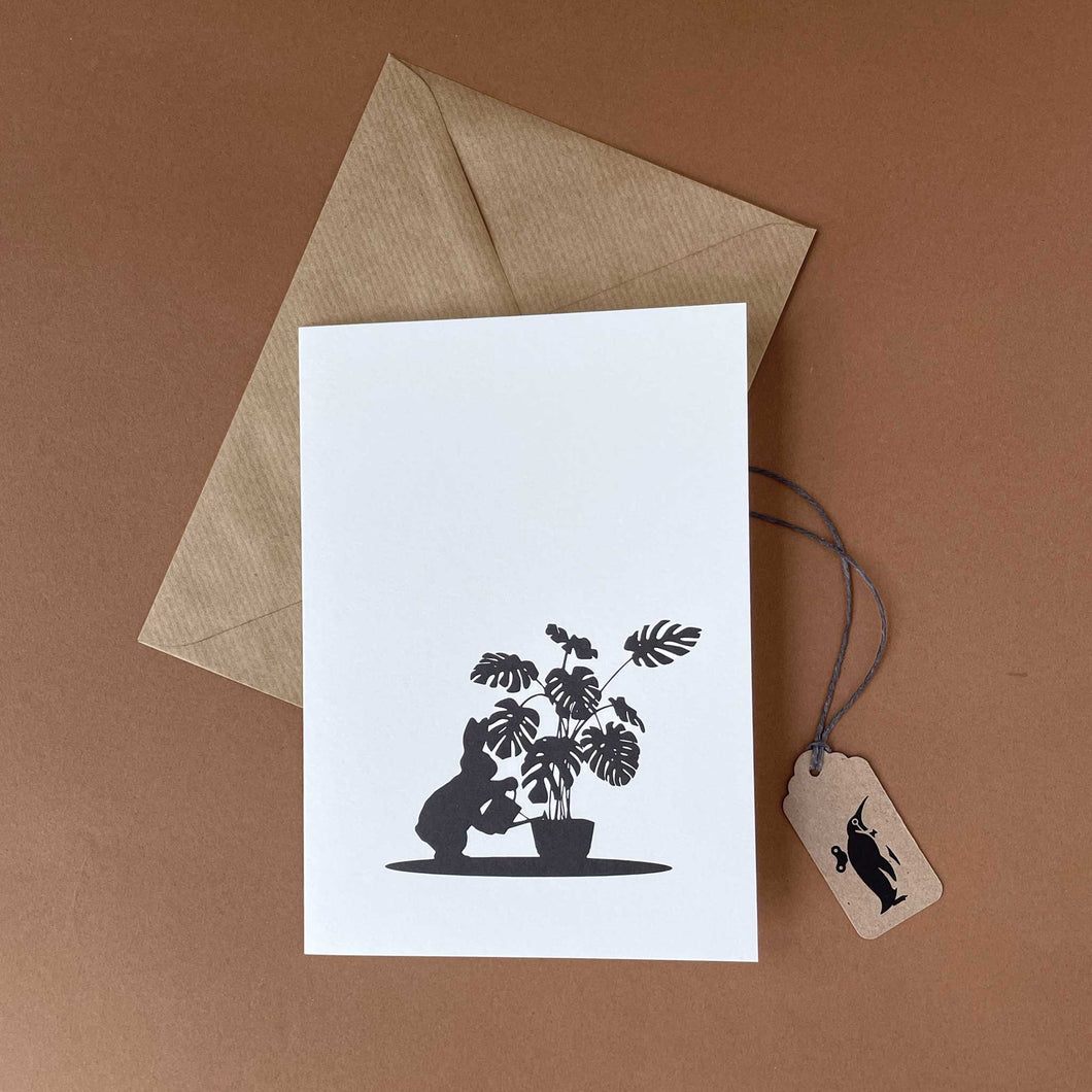 silohuette-rabbit-watering-plants-white-background-and-brown-card