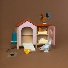 Load image into Gallery viewer, pink-chicken-coop-with-open-doors-showing-a-rooster-two-hens-a-little-chick-and-some-freshly-laid-eggs-two-nests-and-a-feeding-trough