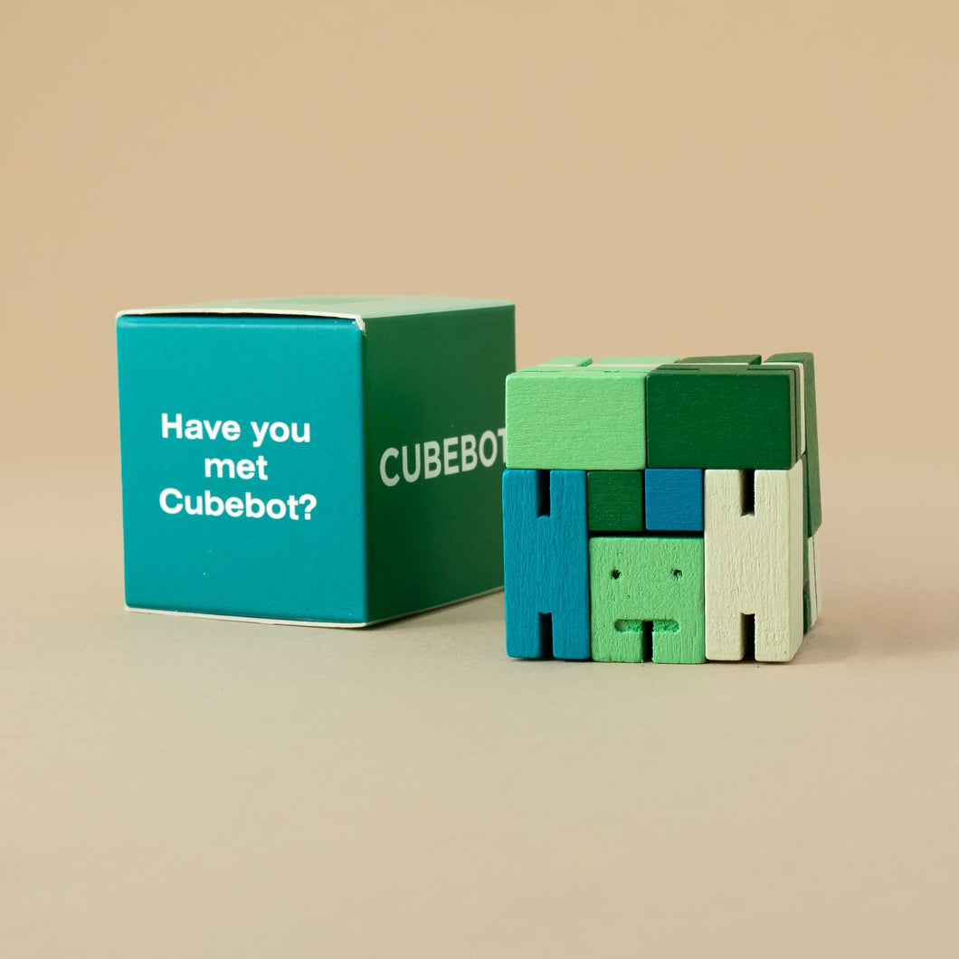 green-toned-cubebot-in-cube-form-next-to-box
