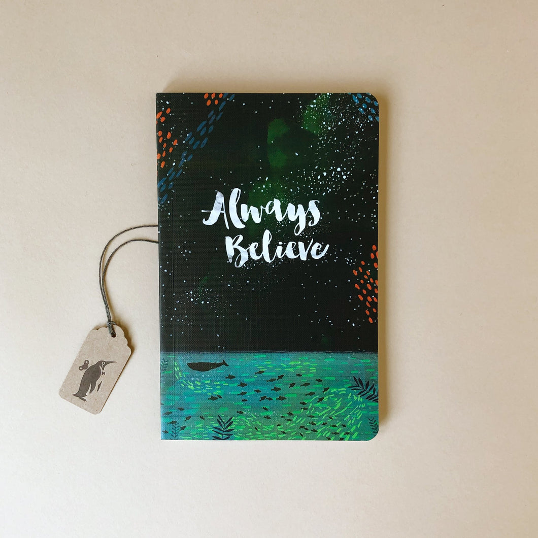 soft-cover-journal-with-the-words-always-believe-and-a-background-of-dark-sky-and-ocean-with-fish